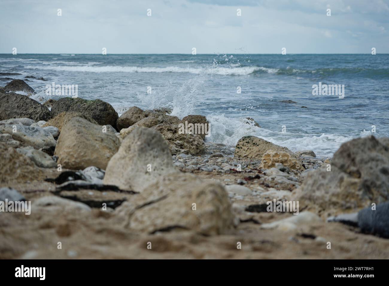 Vagues éclaboussant sur les rochers au bord de la mer. Banque D'Images
