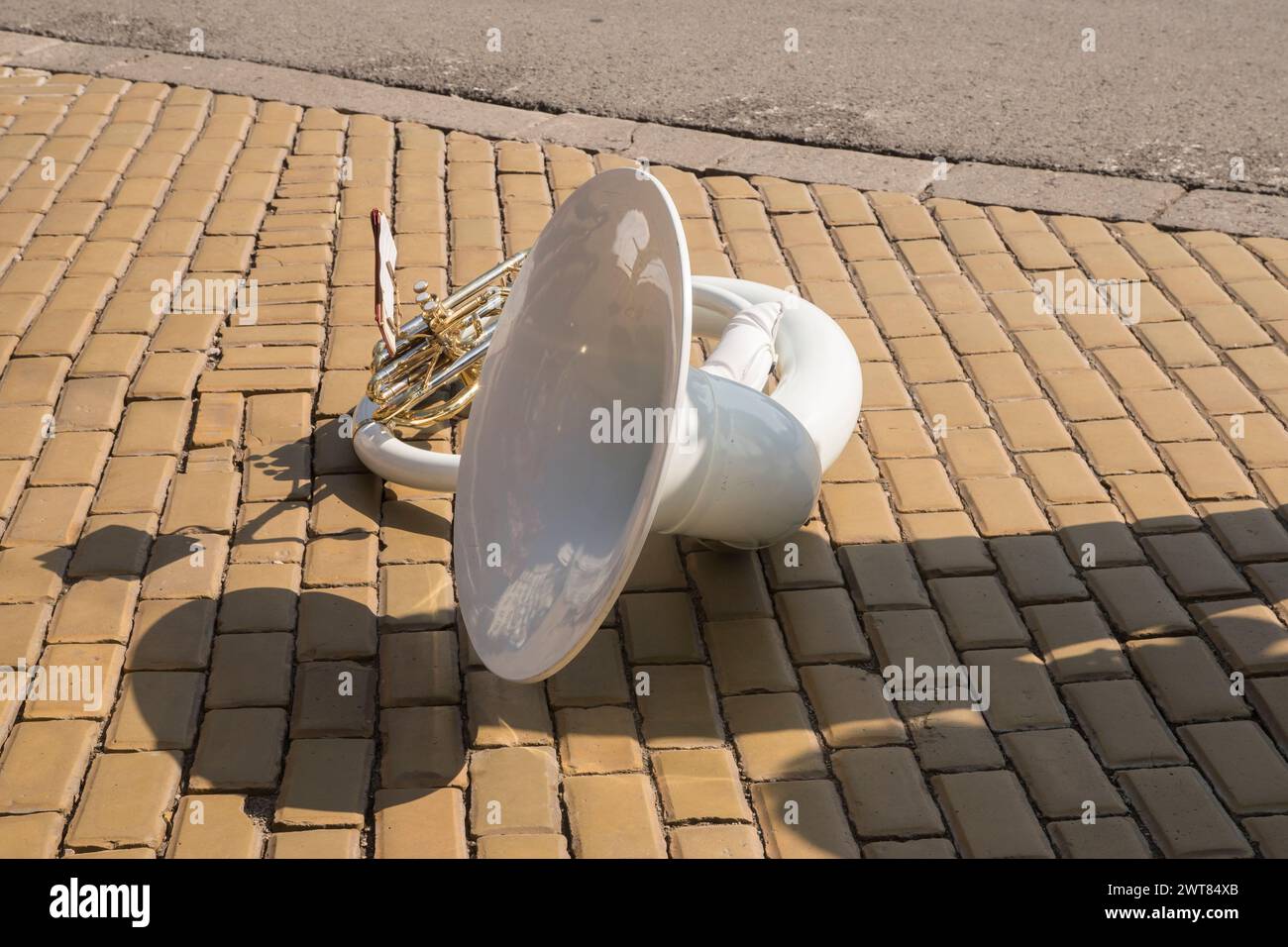 Sousaphone en fibre de verre blanche sur les pavés en céramique de rue de ville en gros plan Banque D'Images