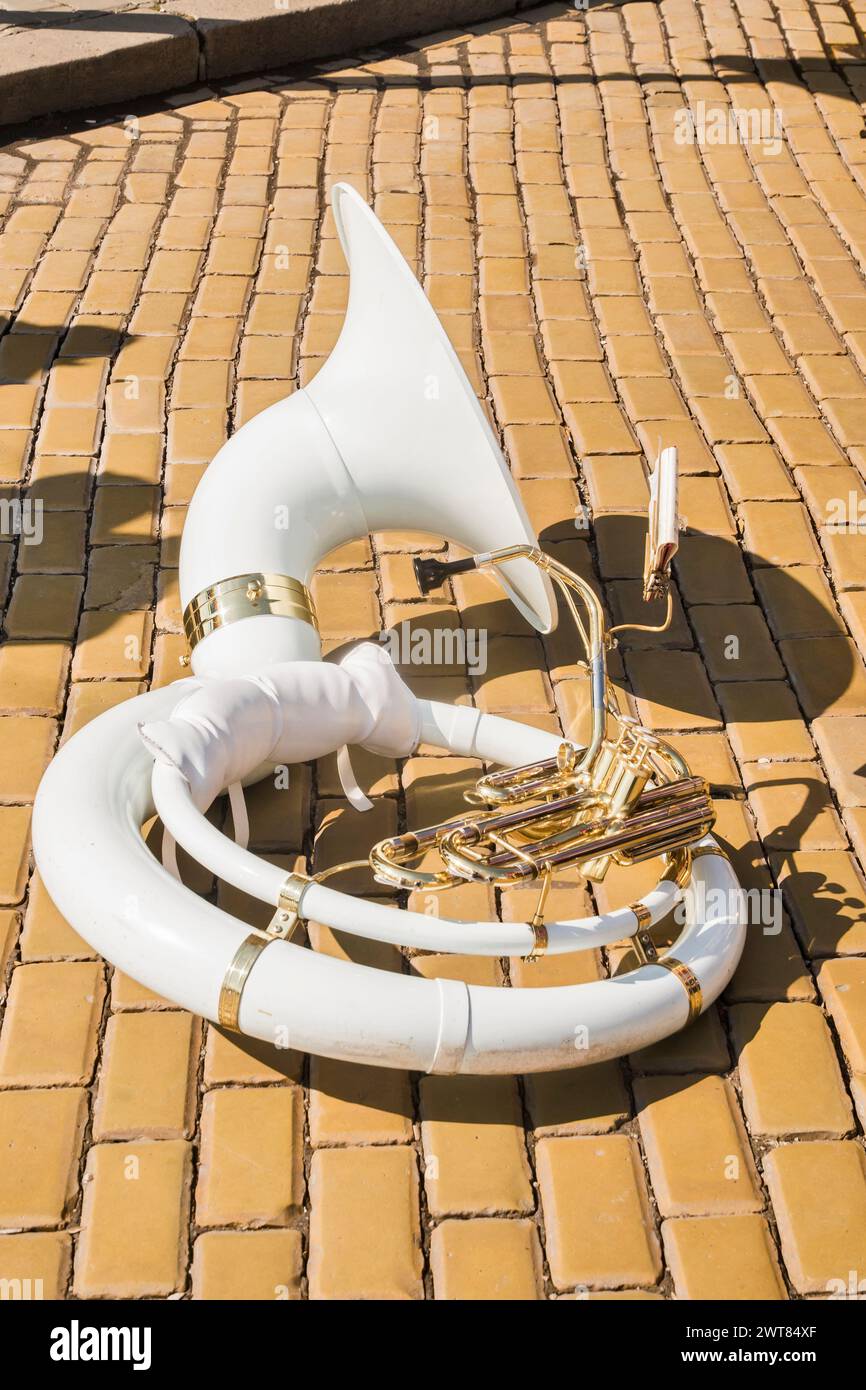 Sousaphone en fibre de verre blanche sur les pavés en céramique de rue de ville en gros plan Banque D'Images