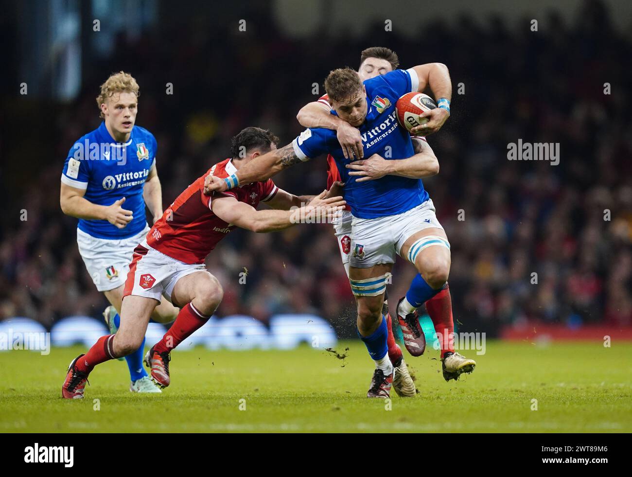 L'Italien Lorenzo Cannone (au centre) est attaqué par le Gallois Tomos Williams (à gauche) lors du Guinness six Nations match au Principality Stadium de Cardiff. Date de la photo : samedi 16 mars 2024. Banque D'Images