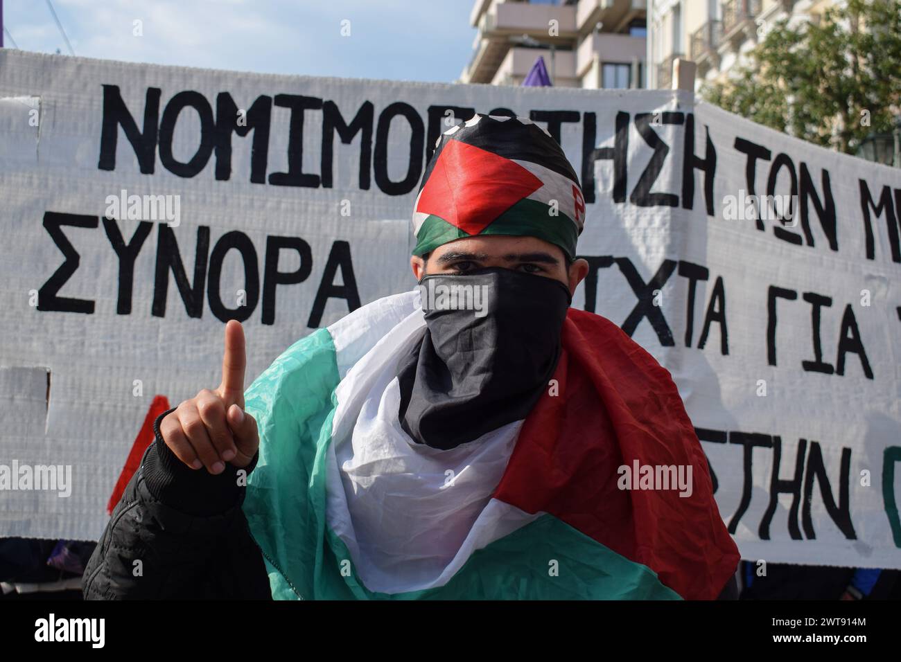 Athènes, Grèce. 16 mars 2024. Un homme couvert d'un drapeau palestinien fait des gestes pendant la manifestation. Immigrants et personnes solidaires ont organisé un rassemblement anti-raciste pour mettre en lumière les problèmes des migrants comme les refoulements aux frontières de l'UE et le Pacte de migration et d'asile de l'UE. Crédit : Dimitris Aspiotis/Alamy Live News Banque D'Images