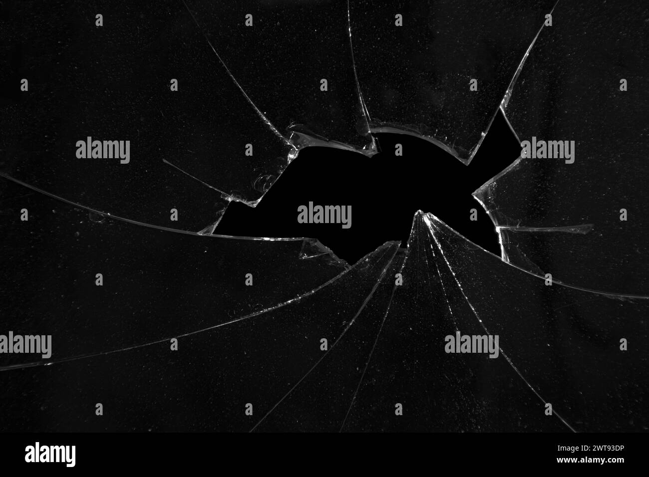 Fissures de verre brisé, texture de fond noir d'un trou dans une fenêtre Banque D'Images