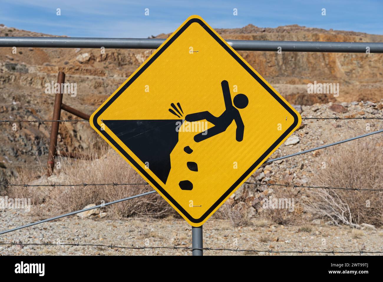 signe de falaise instable d'avertissement jaune et noir sur la clôture devant la mine à ciel ouvert Banque D'Images