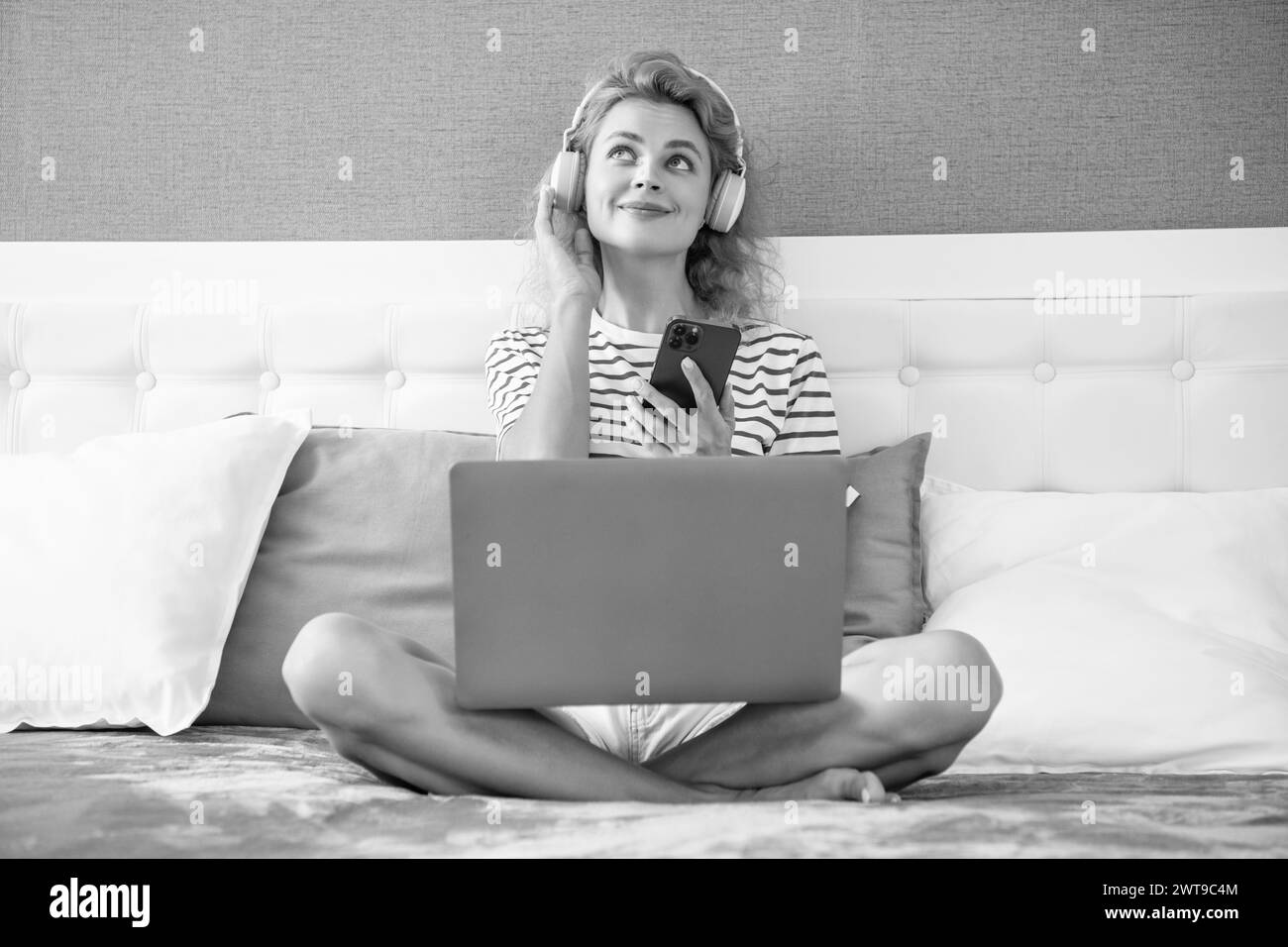 une jeune fille qui écoute de la musique au téléphone. musicophone à la maison. une fille dans un casque écoute de la musique. Banque D'Images