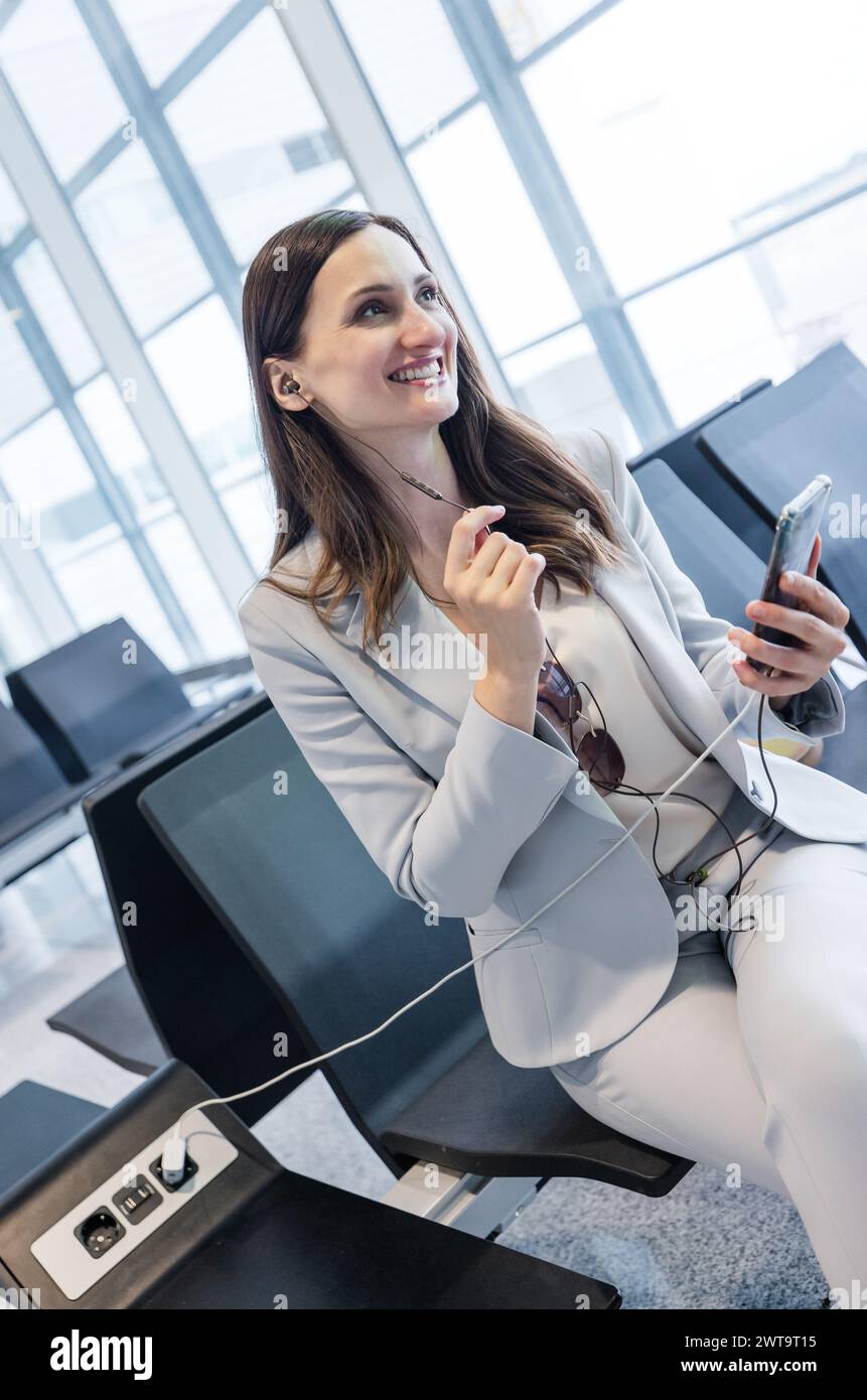femme d'affaires faisant quelques appels rapides liés au travail en attendant l'enregistrement à la porte de l'aéroport Banque D'Images