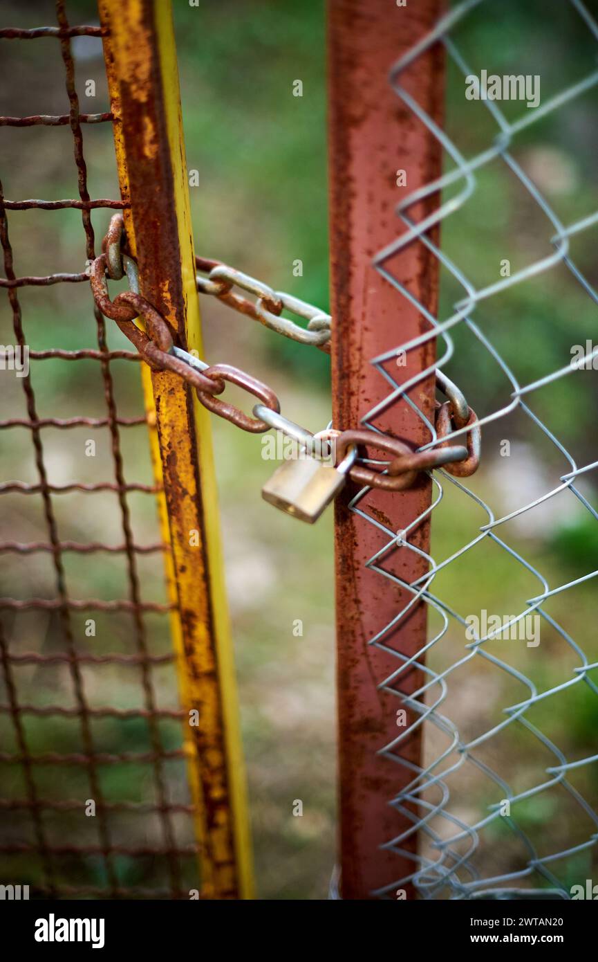 Porte en maille métallique fermée avec chaîne et cadenas. Banque D'Images