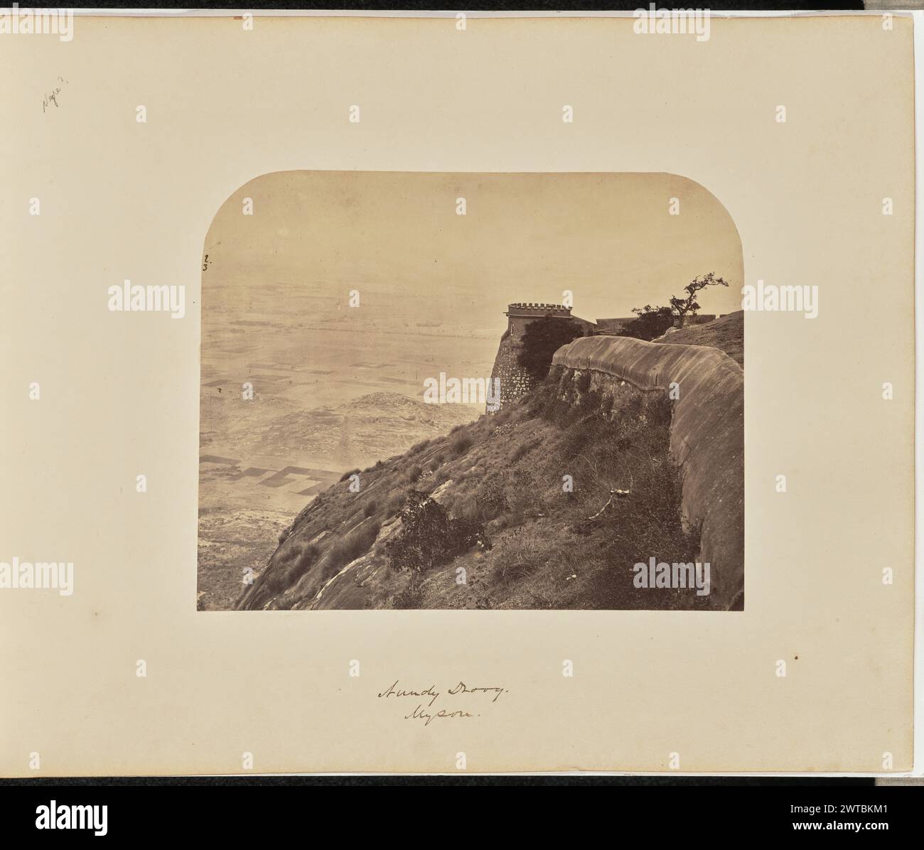 Nundy Droog. Mysore. Inconnu, photographe vers 1866–1870 vue d'un rempart au sommet d'une colline, faisant partie du fort de Nandidrug. Une tour basse surmontée d'un parapet peut être vue surplombant la vaste zone ci-dessous. (Recto, impression) en haut à gauche, à l'encre noire : '2. / 3' ; (recto, monture) en haut à gauche, au crayon : 'Negre? [Inscription inexacte]' ; centre inférieur, à l'encre brune : 'Nundy Droog. / Mysore.' ; (verso, monture) en bas à gauche, au crayon : 'A48.65'; Banque D'Images
