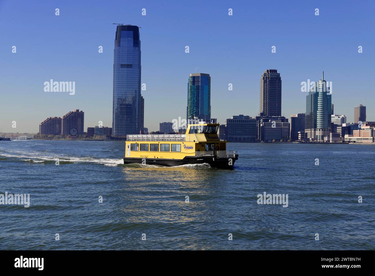 Bateau jaune naviguant sur la rivière en face d'une ligne d'horizon de la ville, centre-ville de Manhattan, Manhattan, New York, États-Unis, Amérique du Nord Banque D'Images