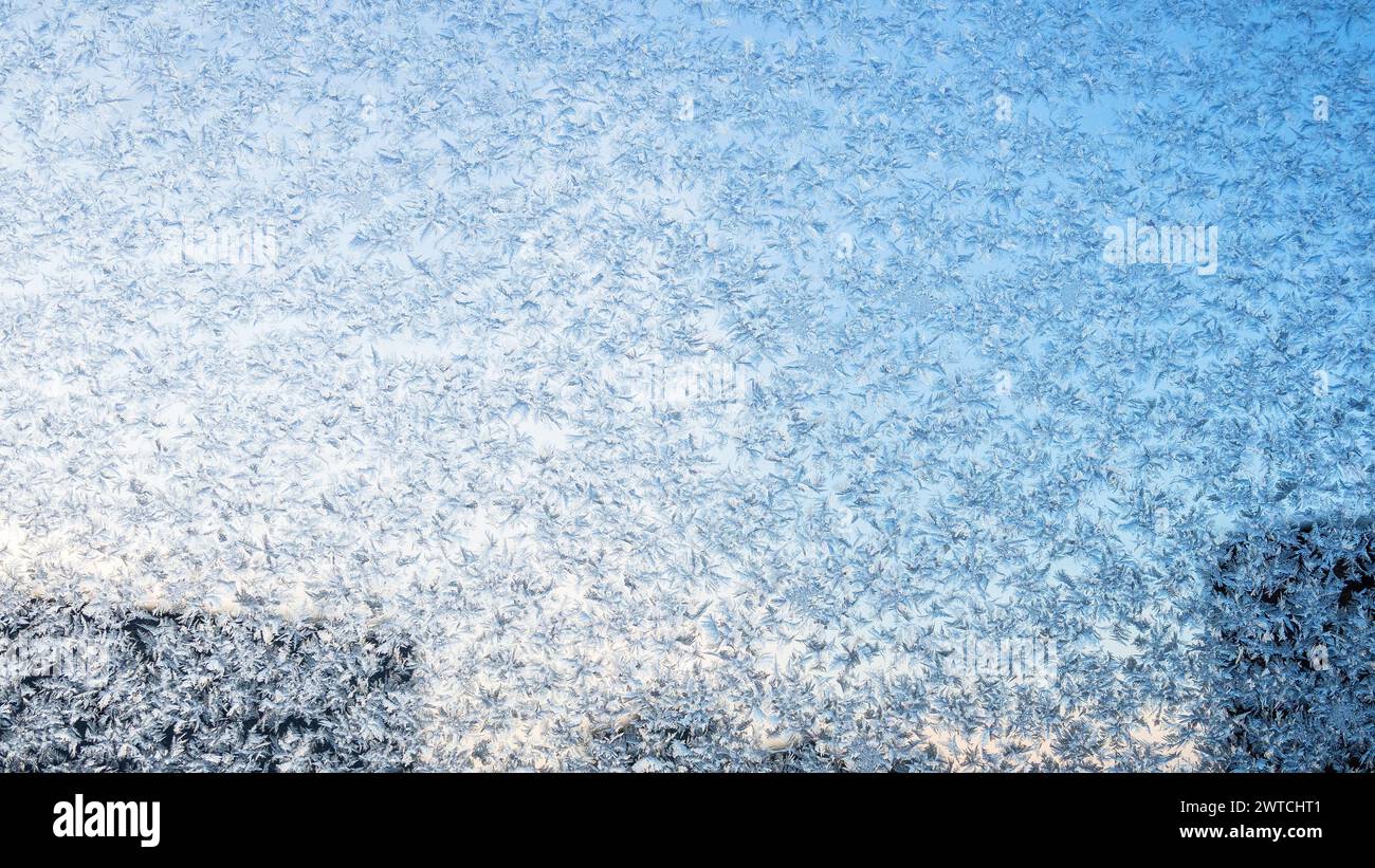 gel sur le verre de fenêtre de l'appartement de ville le soir froid d'hiver et ciel bleu sur fond Banque D'Images