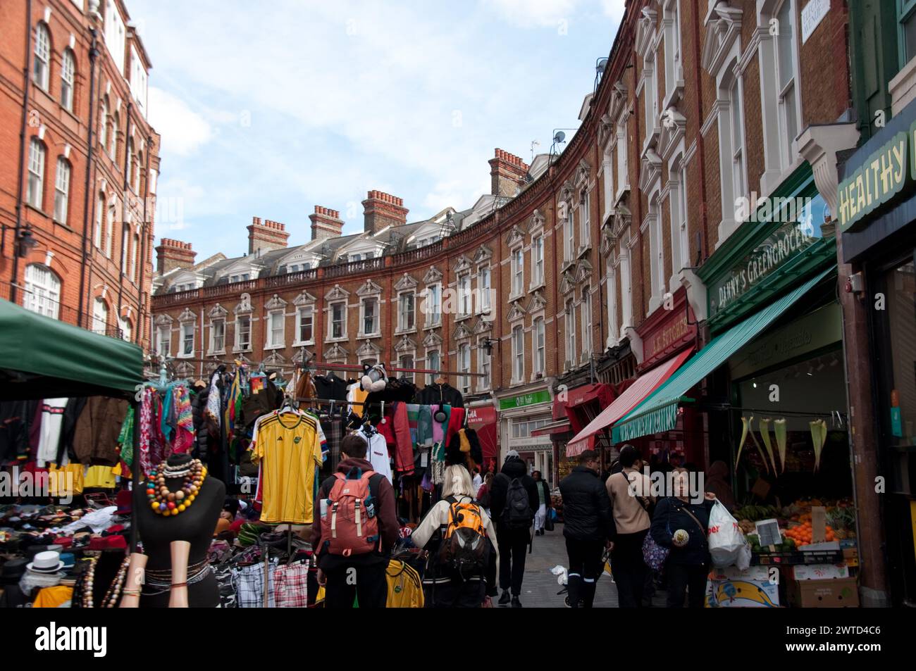 Brixton Market avec d'élégantes maisons en briques rouges au-dessus des boutiques, Electric Lane, Brixton, Londres, Royaume-Uni - rue en forme de croissant Banque D'Images
