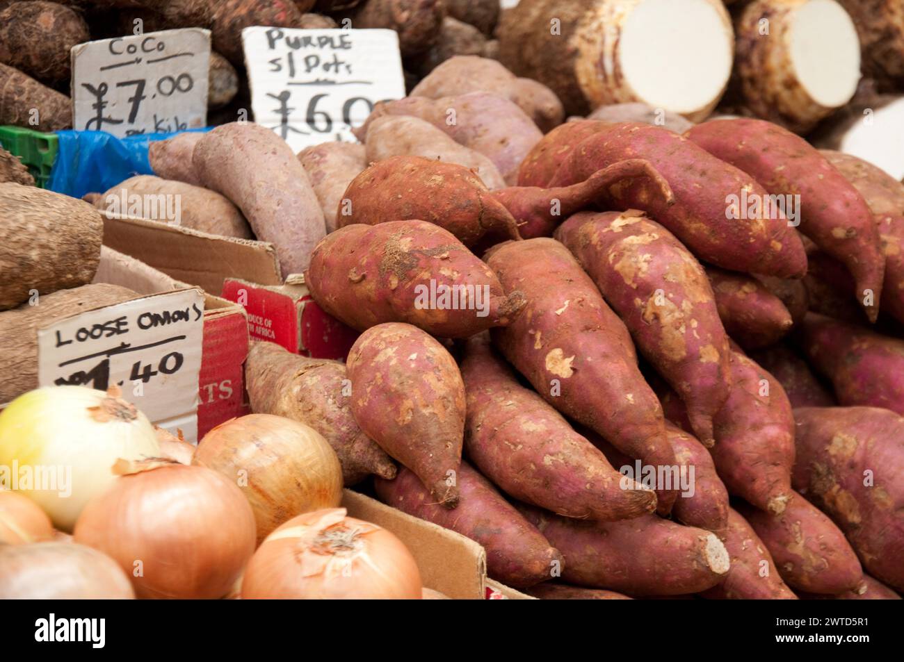 Stand de légumes, Brixton Market, Brixton, Londres, Royaume-Uni; courges ; patates douces ; plantain ; manioc ; nourriture afro-caribéenne; oignons ; pommes de terre Banque D'Images