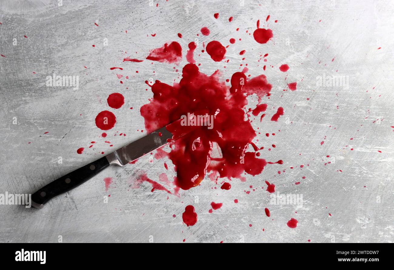 Couteau sanglant se trouve sur fond désordonné. Homicide concept de violence domestique. Piscine de sang. Fond texturé gris clair avec espace de copie. Banque D'Images