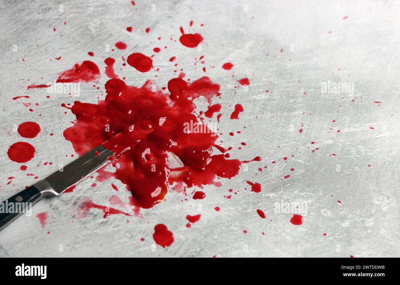 Couteau sanglant se trouve sur fond désordonné. Homicide concept de violence domestique. Piscine de sang. Fond texturé gris clair avec espace de copie. Banque D'Images