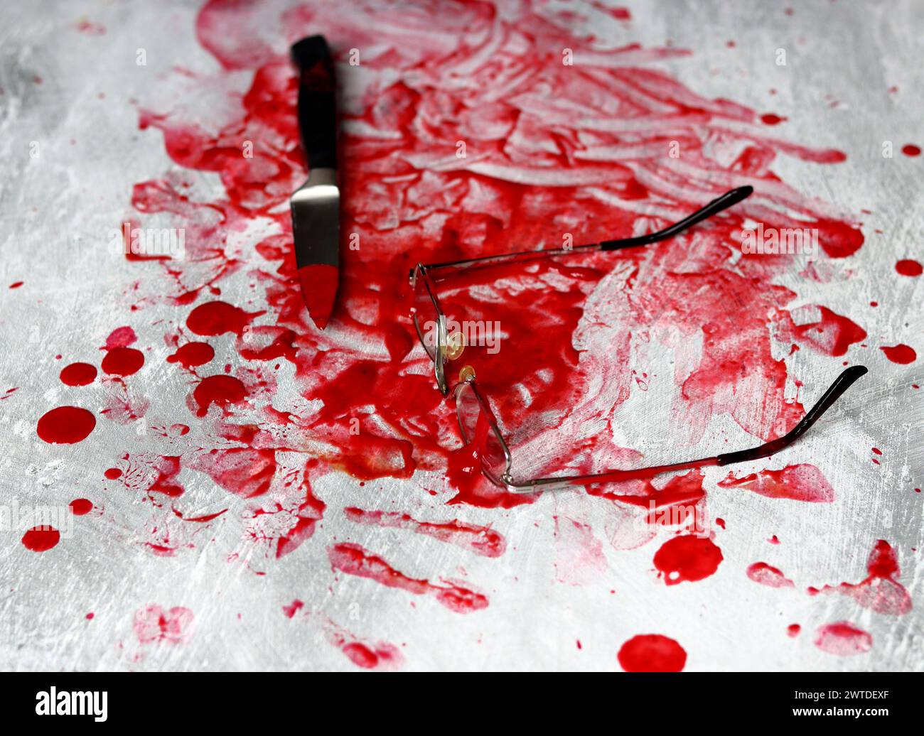 Couteau sanglant se trouve sur fond désordonné. Homicide concept de violence domestique. Piscine de sang. Fond texturé gris clair avec espace de copie. Banque D'Images