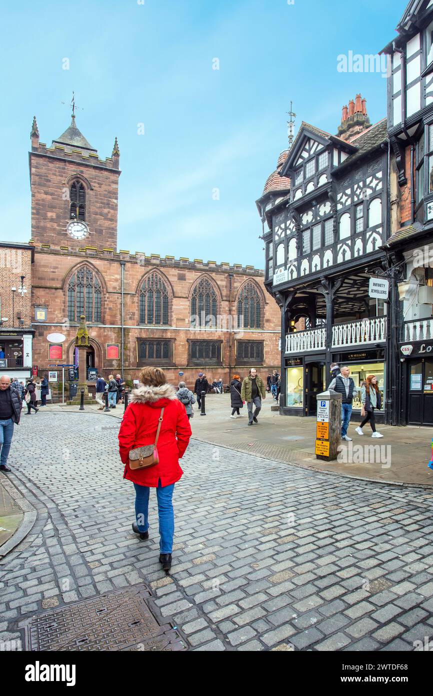 Femme en manteau rouge marchant à travers la ville de Cheshire de Chester Banque D'Images