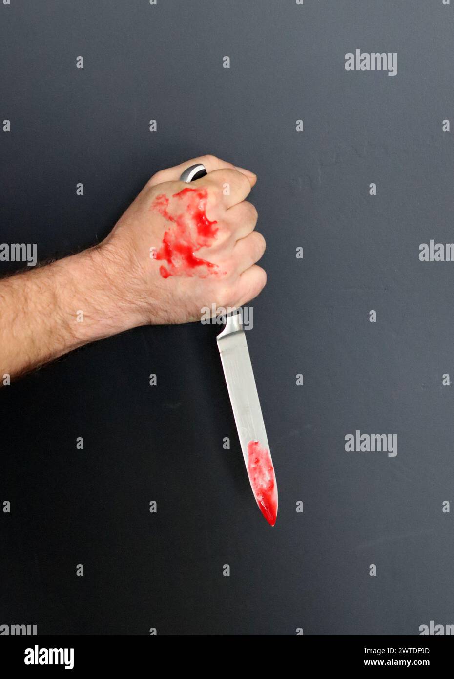 Main sanglante tenant un couteau avec du sang sur un fond noir. Violence domestique Abuse concept de meurtre Banque D'Images