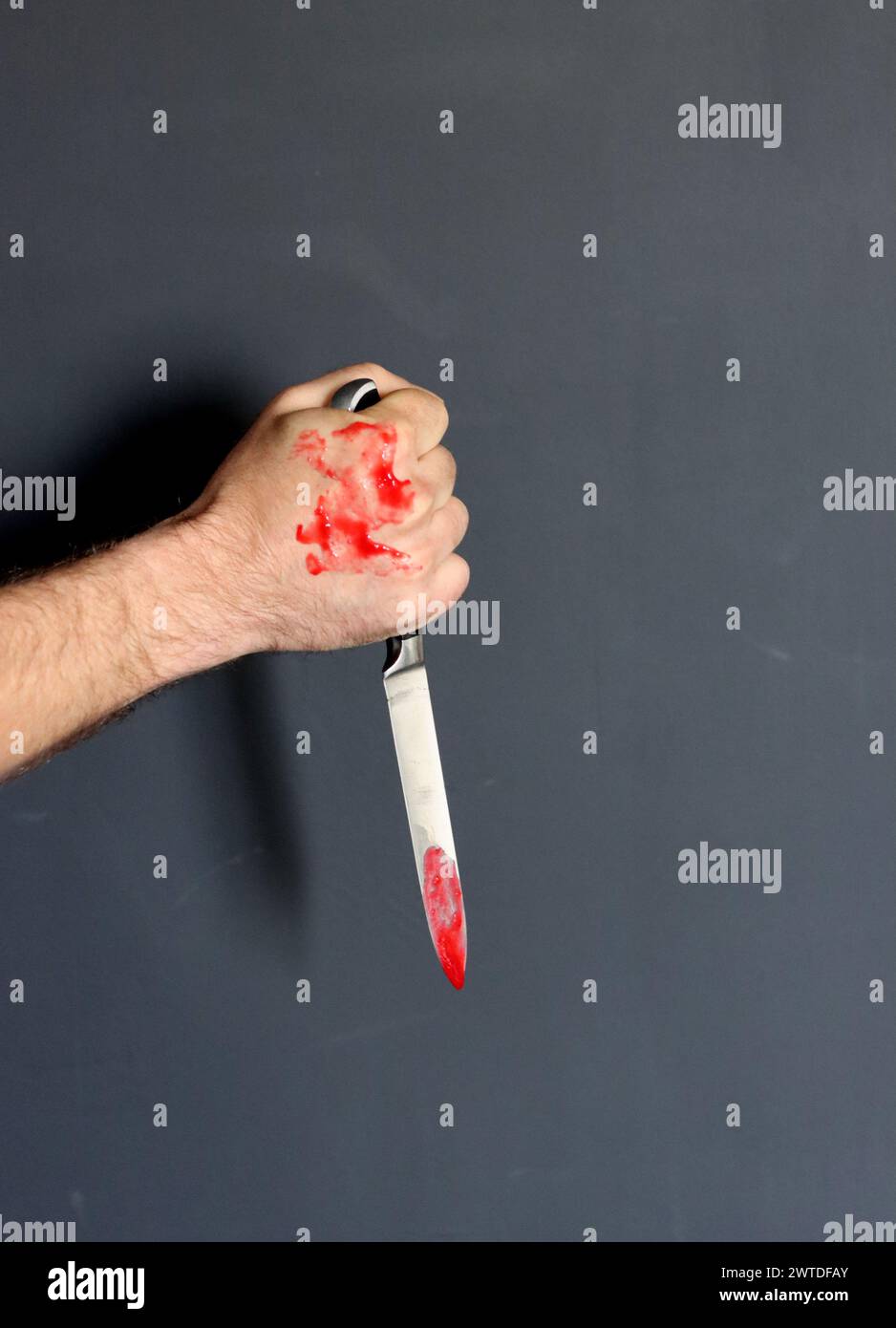 Main sanglante tenant un couteau avec du sang sur un fond noir. Violence domestique Abuse concept de meurtre Banque D'Images