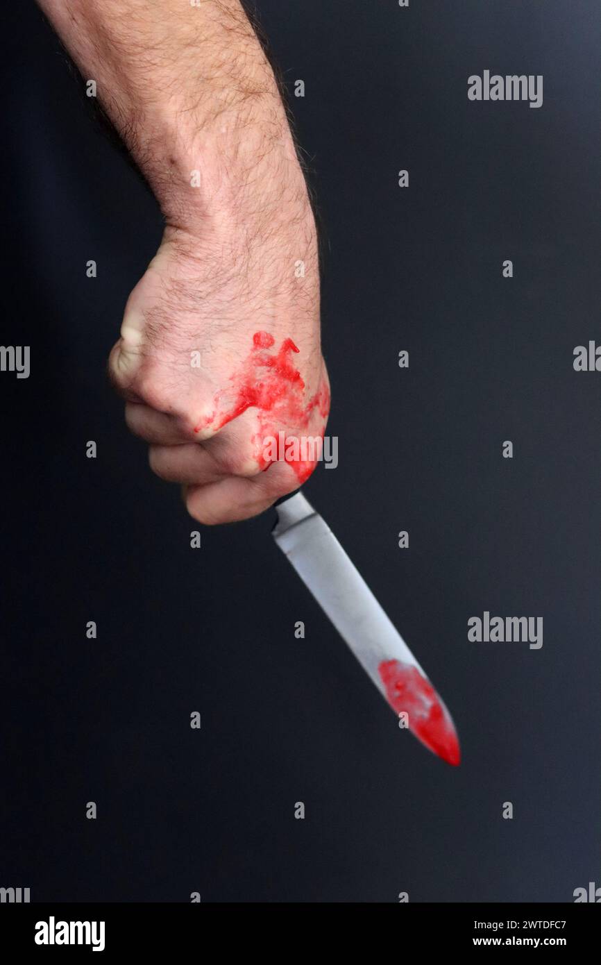 L'homme tient un couteau sanglant. Concept de meurtrier Banque D'Images