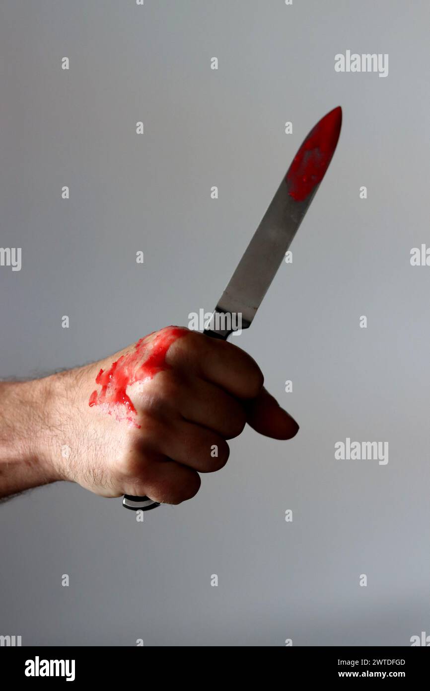 L'homme tient un couteau sanglant. Concept de meurtrier Banque D'Images