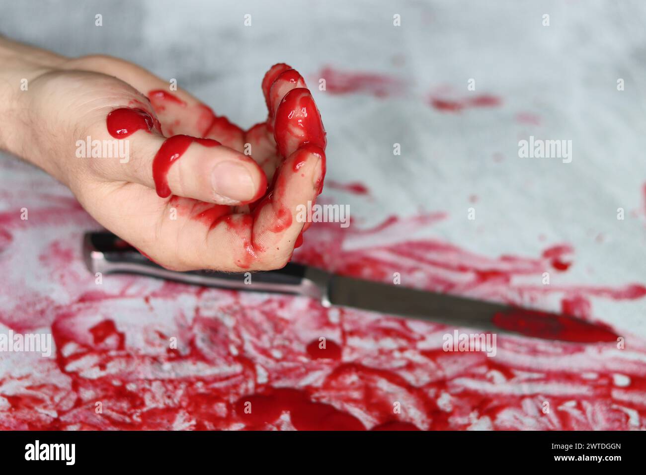 Couteau sanglant se trouve sur fond désordonné. Homicide concept de violence domestique. Piscine de sang. Fond texturé gris clair avec espace de copie. Banque D'Images