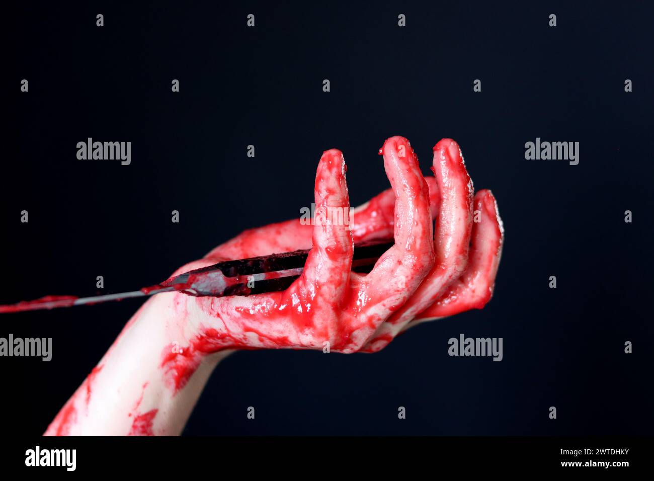 Main sanglante tenant un couteau avec du sang sur un fond noir. Violence domestique Abuse concept de meurtre Banque D'Images