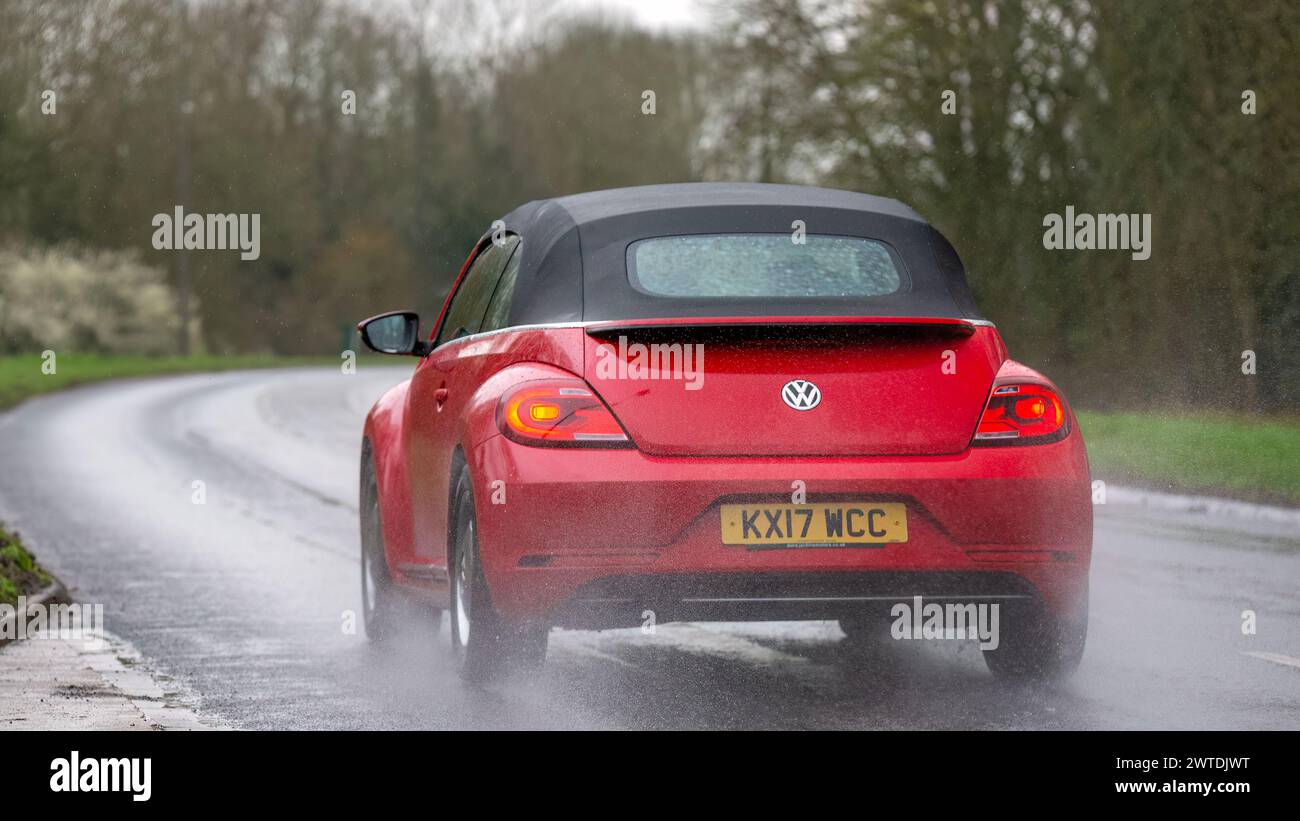 Milton Keynes, UK-Mar 17th 2024 : 2017 rouge, Volkswagen Beetle voiture, vue arrière, conduite sous la pluie Banque D'Images