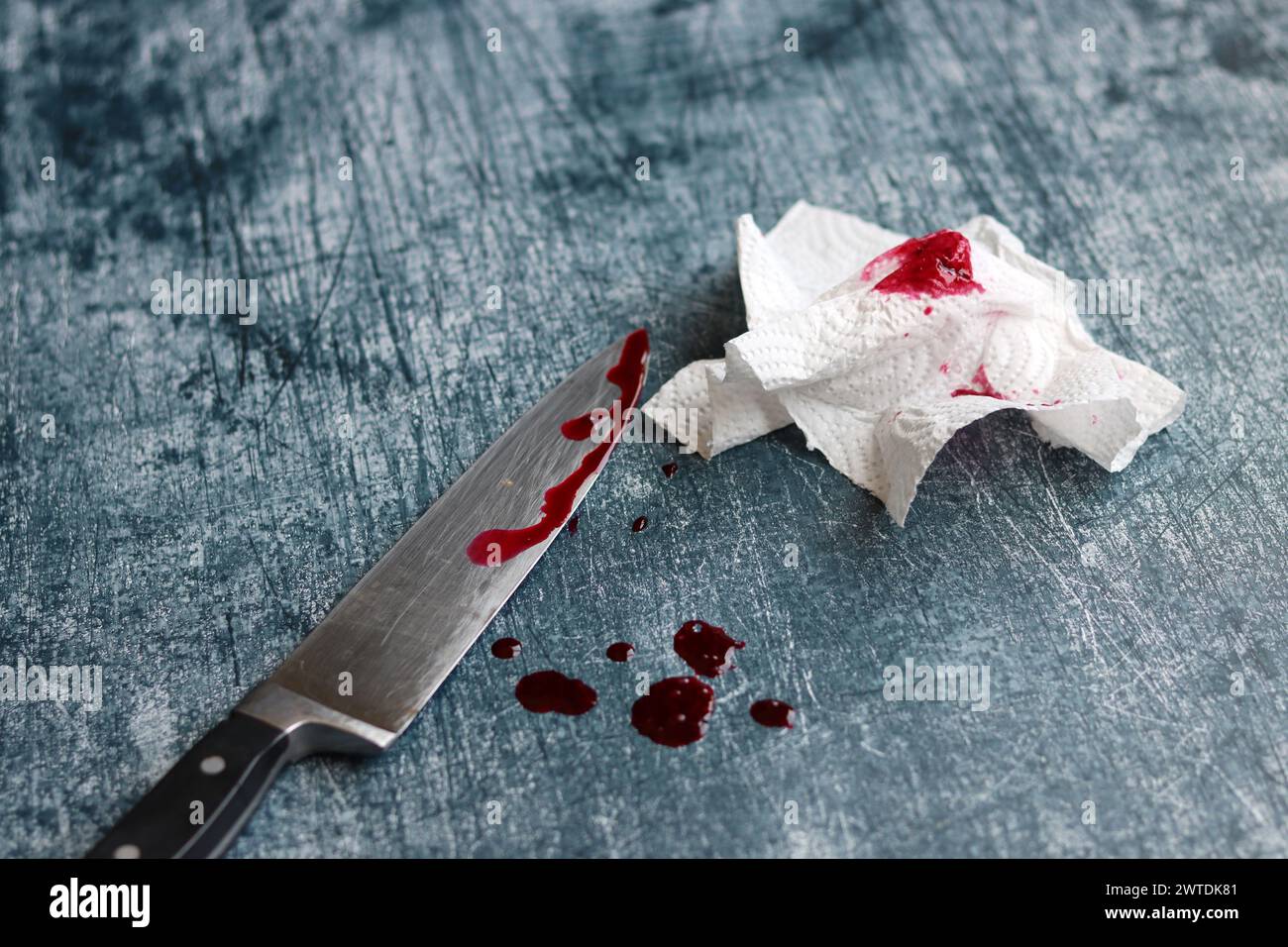 Gros couteau sanglant sur fond gris grungy avec espace de copie. Gouttes de sang sur fond rouillé. Concept de violence domestique. Banque D'Images