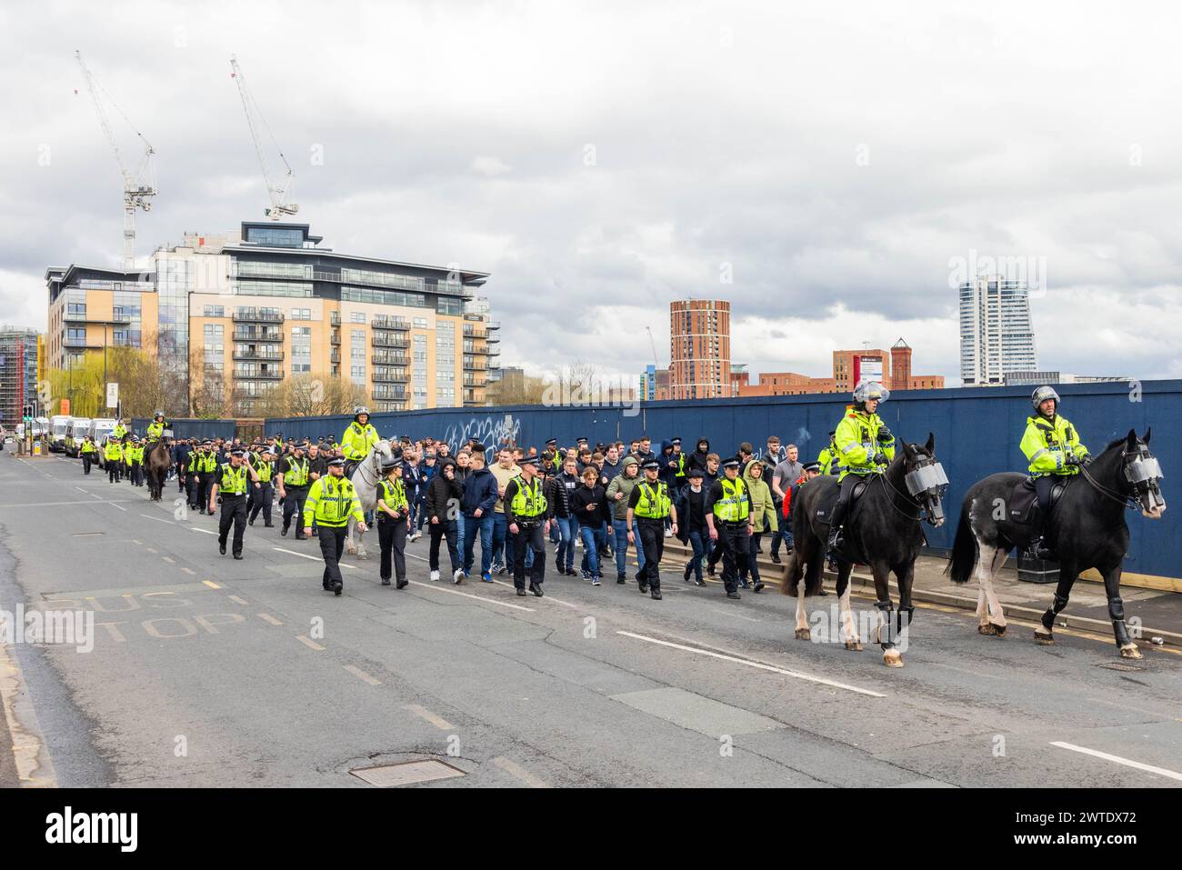 Leeds, Royaume-Uni. 17 MARS 2024. Les fans de Millwall à Leeds alors qu'ils marchent vers Elland Road pour le match de football dans le championnat contre le club de football de Leeds United. Guidés par une police lourde, les fans sont entrés dans le sol sans incident majeur, des chants peu savoureux ont été faits par le groupe tout au long. Crédit Milo Chandler/Alamy Live News Banque D'Images