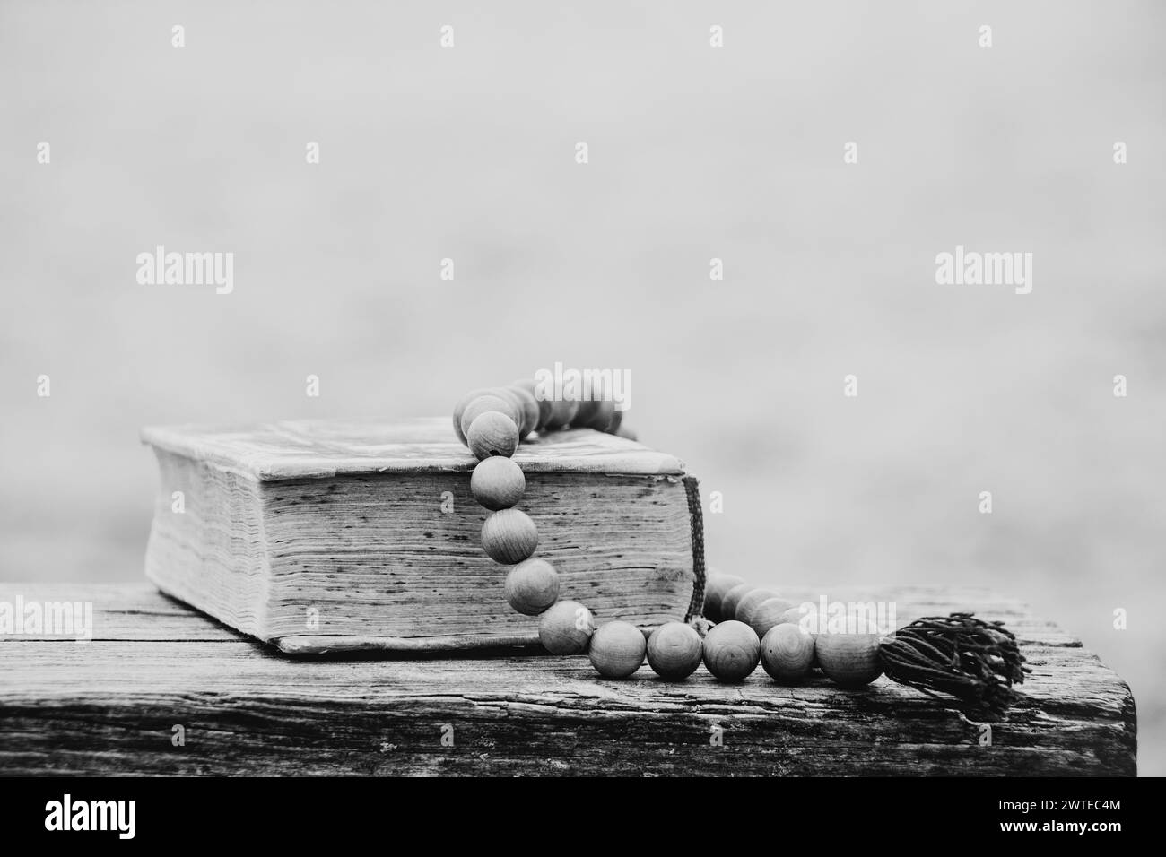 Un vieux livre et chapelet en bois reposent sur des bancs dans les parcs en Ukraine, foi et religion, priez Banque D'Images
