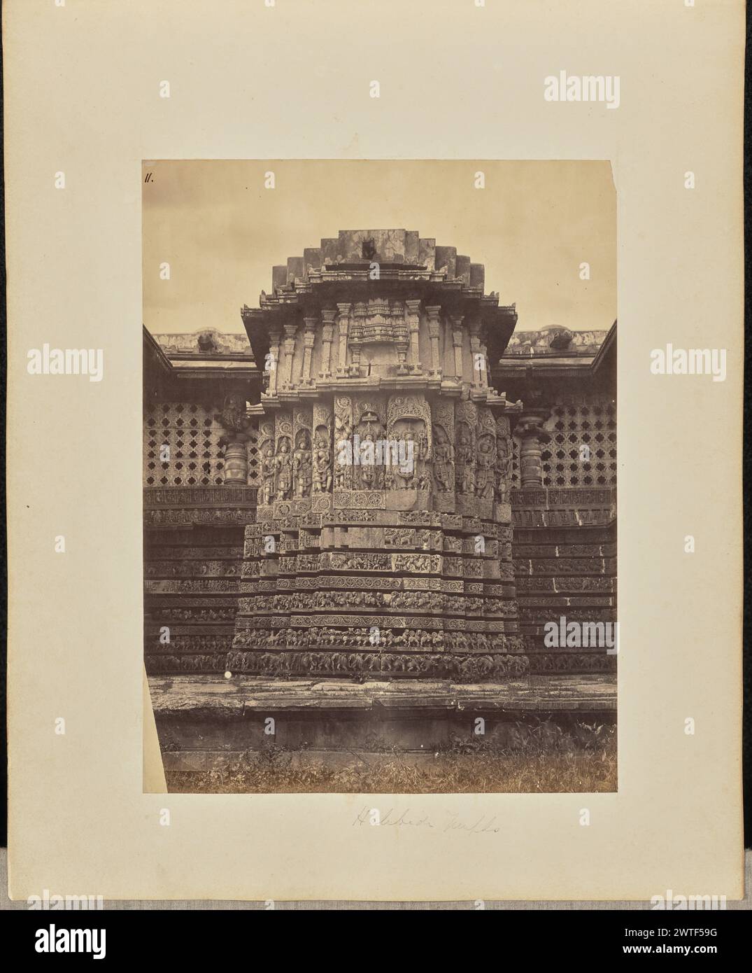 Temple Halibedi. Inconnu, photographe vers 1866–1870 vue d'une section du temple Hoysalesvara, également connu sous le nom de temple Halebidu, montrant un mur en saillie qui est finement sculpté avec des reliefs. Des écrans en pierre perforée sont installés dans les murs adjacents. (Recto, impression) en haut à gauche, à l'encre noire : '11.' ; (recto, monture) en bas au centre, au crayon : 'Halibedi Temple' ; (verso, monture) en bas à droite, au crayon : 'A48.47 [latéralement]'; Banque D'Images
