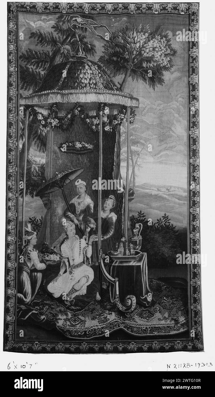 Empress's Tea. Vernansal, Guy-Louis (français, 1648-1729) (auteur de design, attr.) [Peintre] Monnoyer, Jean-Baptiste (français, 1636-1699) (auteur pour design) [peintre] Belin, Jean-Baptiste I (français, 1653-1715) (auteur du design) [peintre] c. 1700-1725 tapisserie dimensions : H 10'7' x W 6' tapisserie matériaux/techniques : inconnue culture : Centre de tissage français : Beauvais histoire de la propriété : Français & Co. Dans un paysage avec des arbres et sous un pavillon en forme de dôme orné de marécages floraux et d'un circlet de fleurs, l'impératrice assise lève la main pour prendre une tasse de thé versée par un serviteur debout à côté du palier de table Banque D'Images