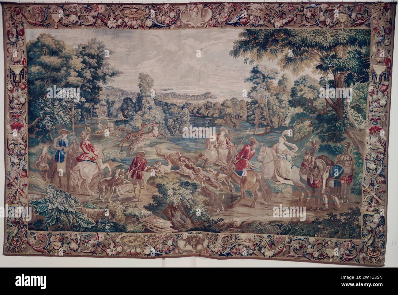 Paysage avec Mesdames et messieurs sur la chasse au cerf. Inconnu c. 1700-1730 dimensions de tapisserie : H 11'4' x l 17'3' tapisserie matériaux/techniques : inconnu culture : Centre de tissage flamand : Bruxelles histoire de propriété : Potsdam, Royal coll. French & Co acheté de H.B. Jacobs 2/1927 ; vendu à Monbuse [Monbusc ?] Inc 10/1959 ; expédié à Anders Jahre 11/1959. Mesdames et messieurs sur la chasse à cheval, les chiens chassant les cerfs (BRD) guirlande de fleurs, feuillage ondulé parsemé d'oiseaux, de paniers de fruits et de quivers ; (centre UPR BRD & LWR BRD) cartouche avec trophée de chasse feuille de stock français et coréens en arc Banque D'Images