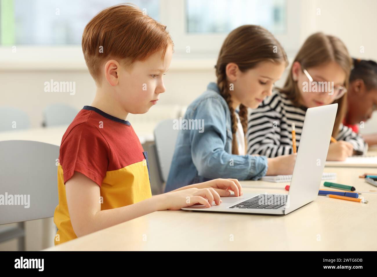 Enfants mignons qui étudient en classe à l'école Banque D'Images