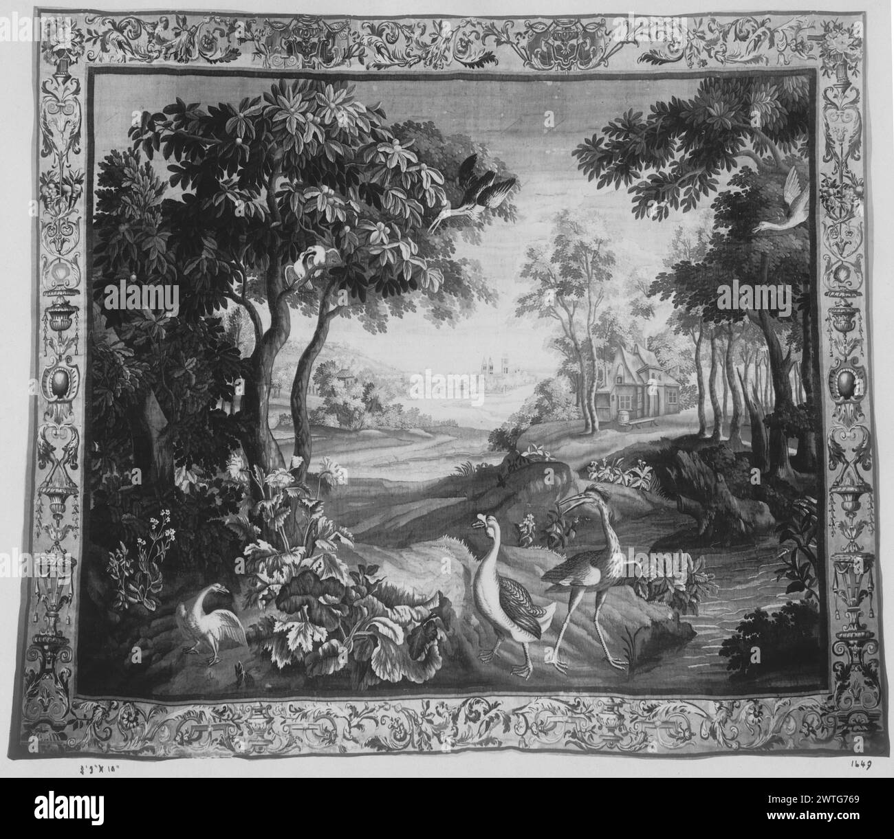 Paysage avec volaille d'eau. Inconnu c. 1700 dimensions de tapisserie : H 11'7' x l 13'2' tapisserie matériaux/techniques : inconnu culture : Centre de tissage français : Beauvais histoire de propriété : Français & Co. acheté de Bacri Frères, reçu le 1/19/1917 ; vendu au M.R. [Mirten] 12/16/1961. Héron et oie regardant vers un autre oiseau à gauche, parmi les plantes sauvages et les arbres près de la rivière en premier plan ; bâtiments de chaque côté de la rivière sinueuse en arrière-plan ; oiseaux supplémentaires dans l'arbre et le vol (BRD) bordure décorative avec défilement des feuilles d'acanthus mélangées avec des crochets avec des pendaisons de pompon, surmonté de cornucopies, vase Banque D'Images