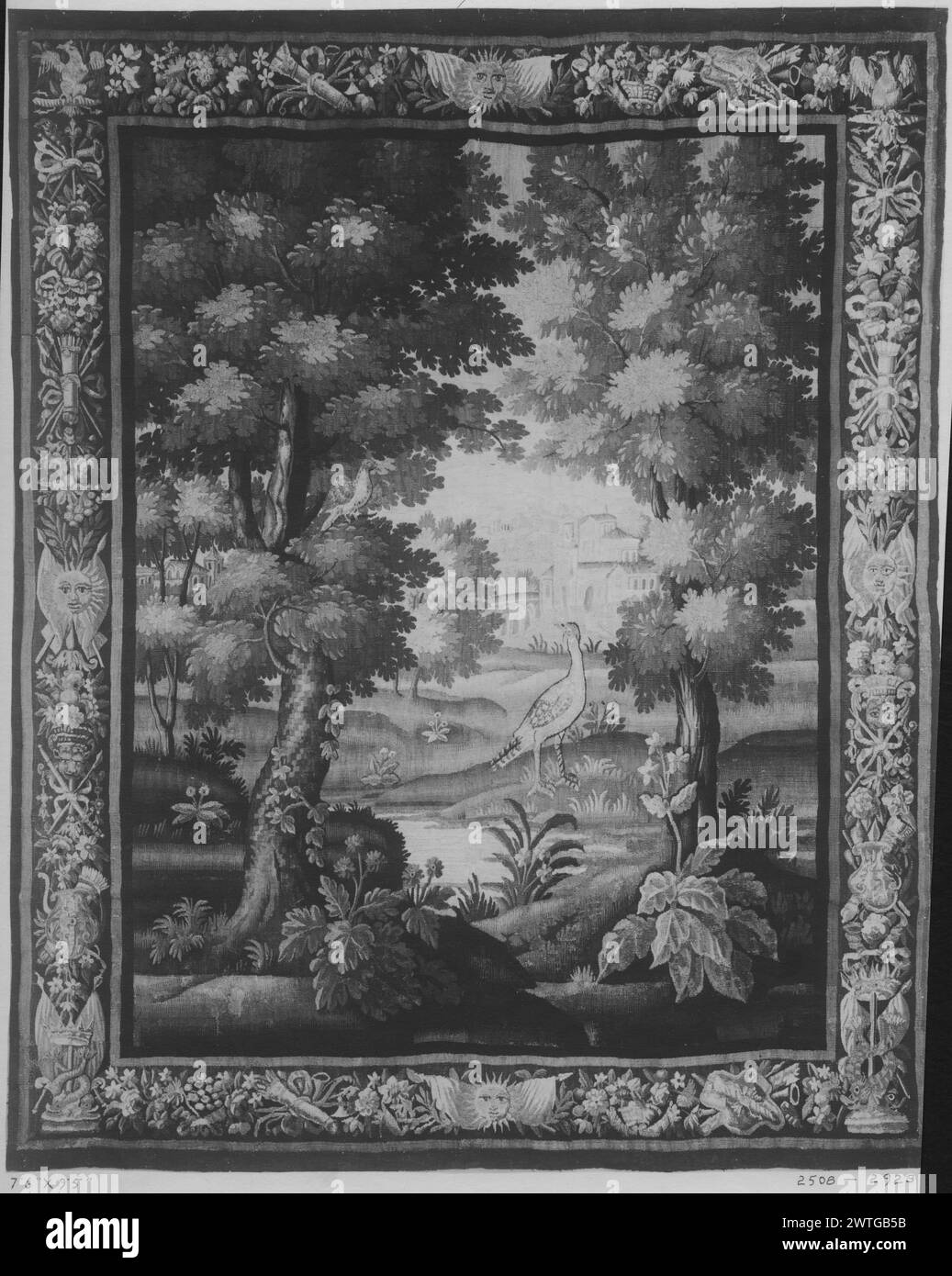 Paysage avec gibier-oiseau. Unknown c. 1675-1700 dimensions de tapisserie : H 9'5' x l 7'6' matériaux/techniques de tapisserie : inconnu culture : Centre de tissage français : Aubusson historique de propriété : French & Co. acheté de Wanamaker, reçu le 2/8/1916 ; vendu à J. Wanamaker le 1/28/1920. Faisan (?) Au premier plan parmi les plantes à fleurs et les arbres, tourné vers oiseau dans l'arbre (l) ; rivière au centre menant à un grand bâtiment avec des arches en arrière-plan ; bâtiment supplémentaire caché derrière les arbres (l) (BRD) bordure incorporant panier de fleurs, fruits et fleurs avec trophées noués ruban, masques grotesques et autres décors Banque D'Images