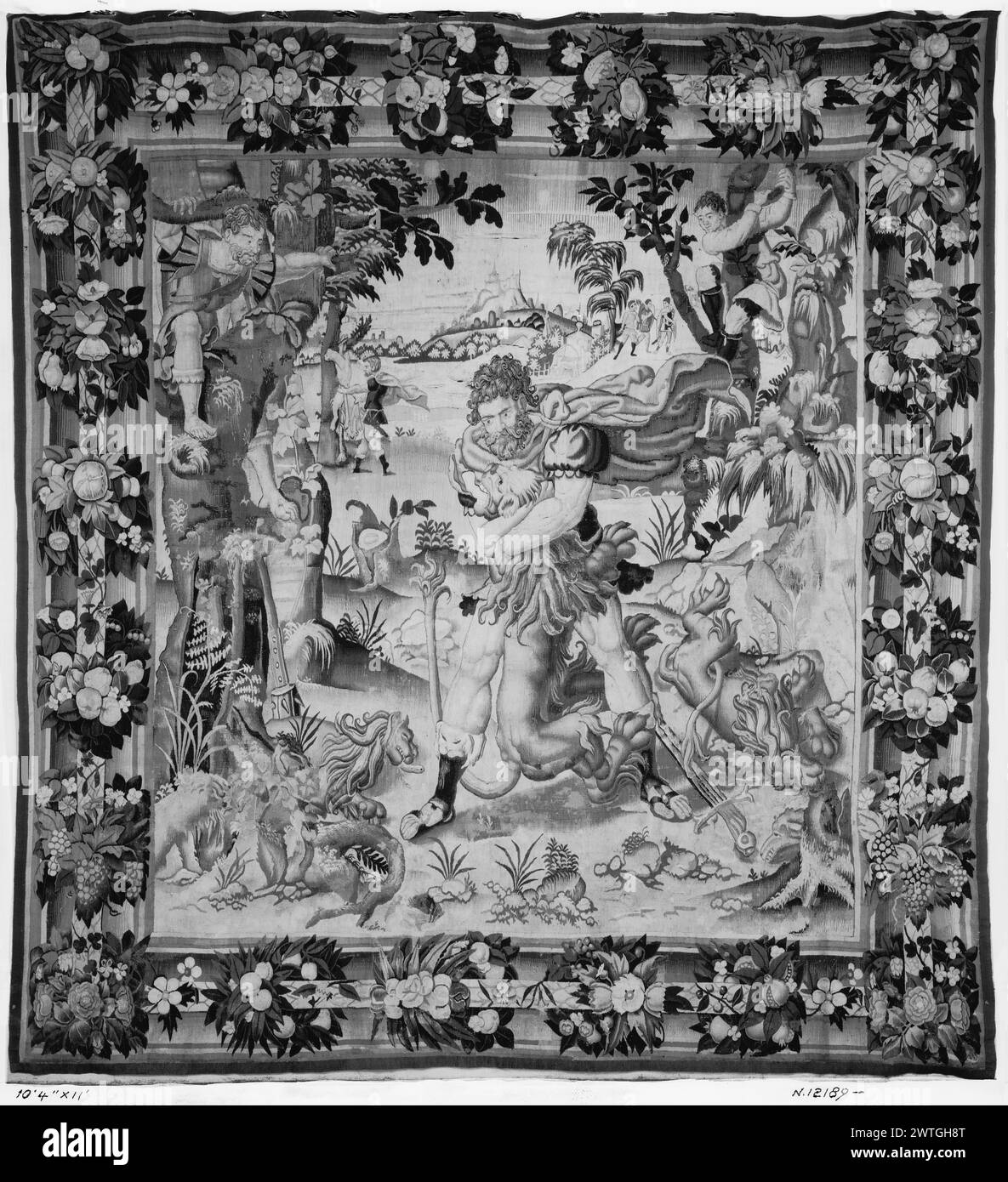 Travaux d'Hercule (1er) : Hercule étouffe le lion de Némée avec ses bras. Inconnu c. 1535-1550 dimensions de tapisserie : H 11' x l 10'4' matériaux / techniques de tapisserie : inconnu culture : Centre de tissage flamand : inconnu histoire de propriété : Français et Co. D'autres lions sont morts sur le sol (BRD) bouquets de fleurs et de fruits contre motif de palmier pas de feuille de stock française et américaine dans les archives, pas de numéro de stock Banque D'Images