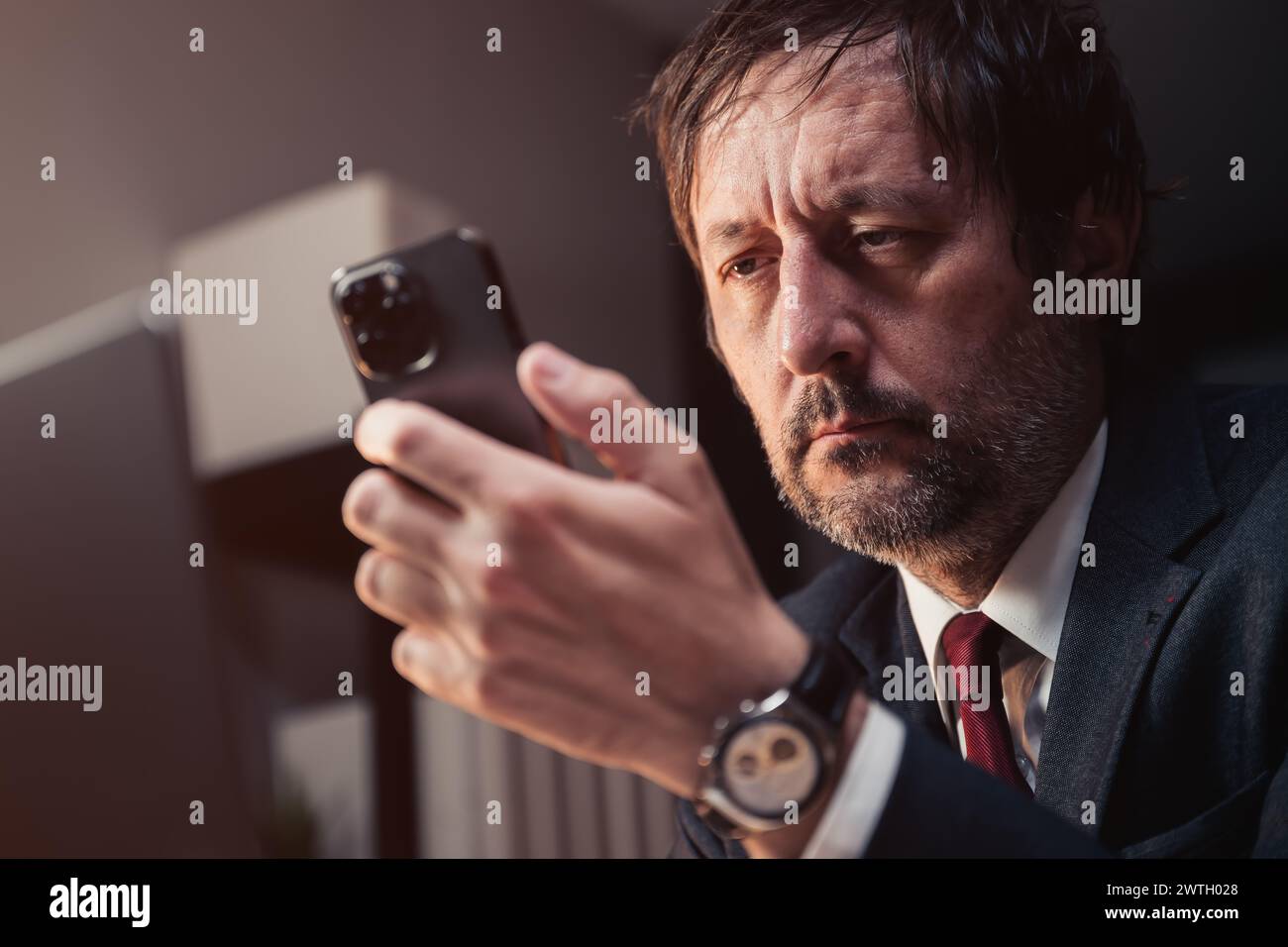 Homme d'affaires utilisant smartphone tard dans la nuit dans le bureau d'affaires, focus sélectif Banque D'Images