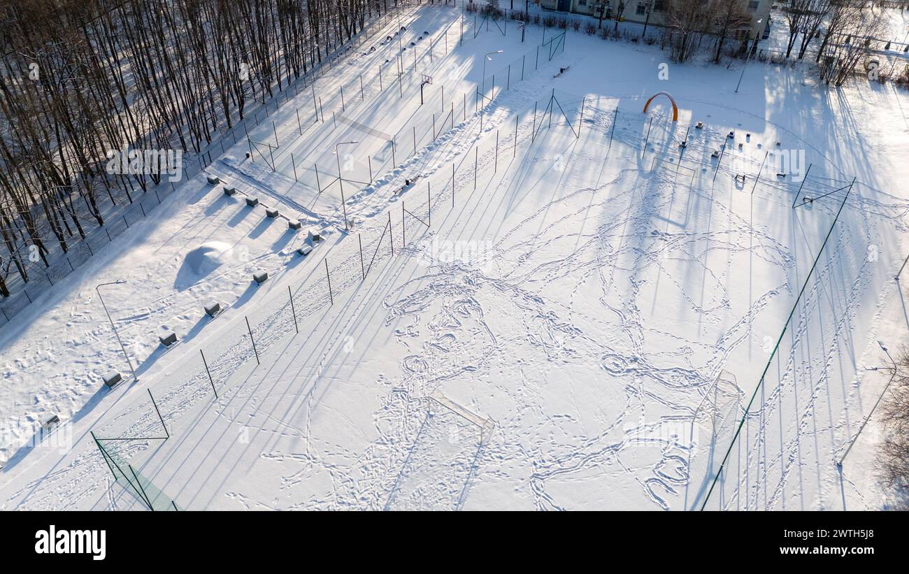 Photographie par drone de terrains de football, de basket-ball et de volley-ball couverts par la neige pendant la journée ensoleillée d'hiver Banque D'Images