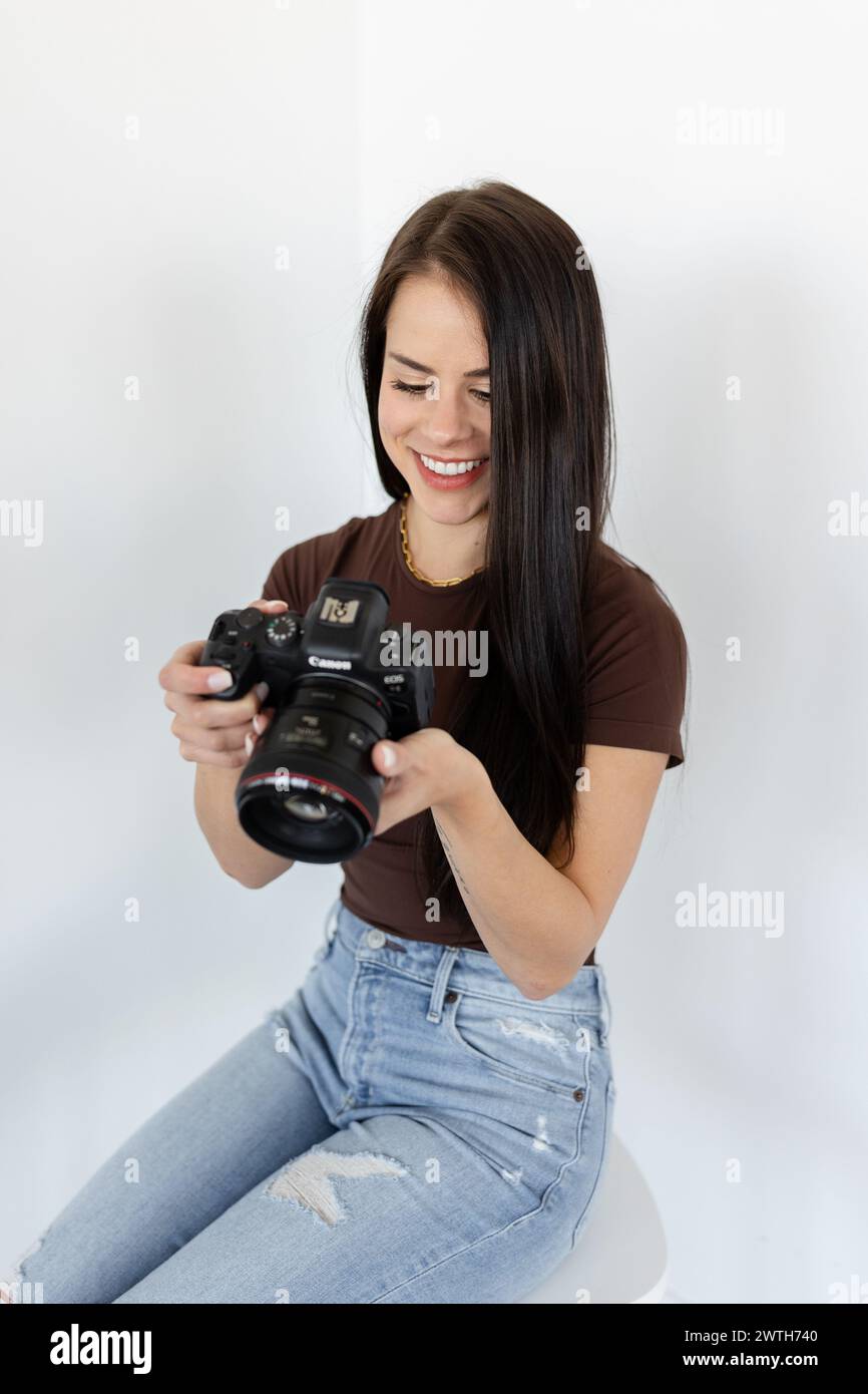 Femme heureuse examinant des photos sur l'appareil photo Canon Banque D'Images