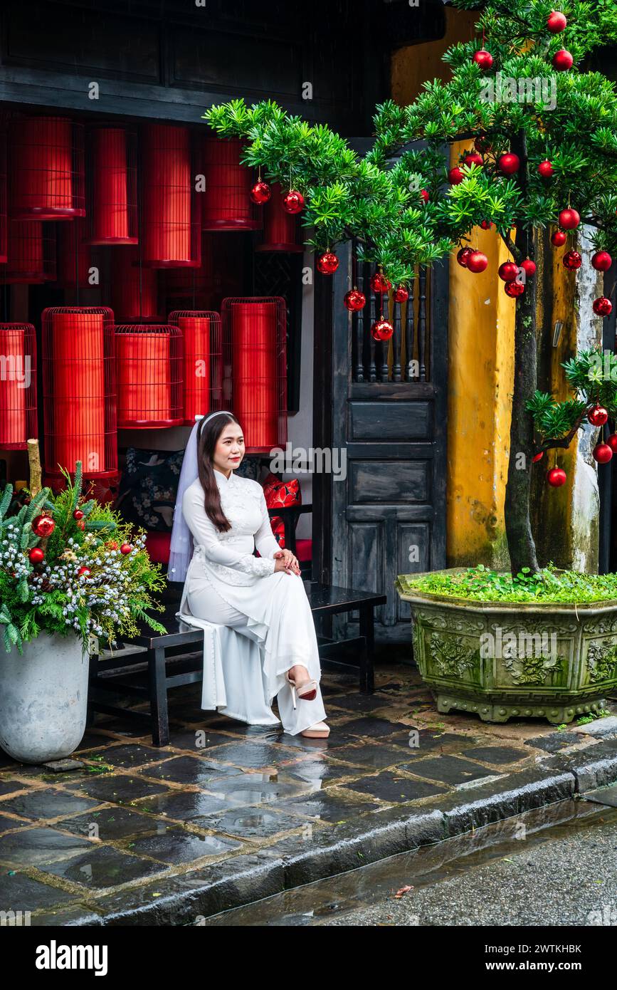 Hoi an, Vietnam, 21 novembre 2022 : une jeune femme en robe de mariée pose pour une photo devant un magasin traditionnel vietnamien à Hoi an, Vietnam Banque D'Images
