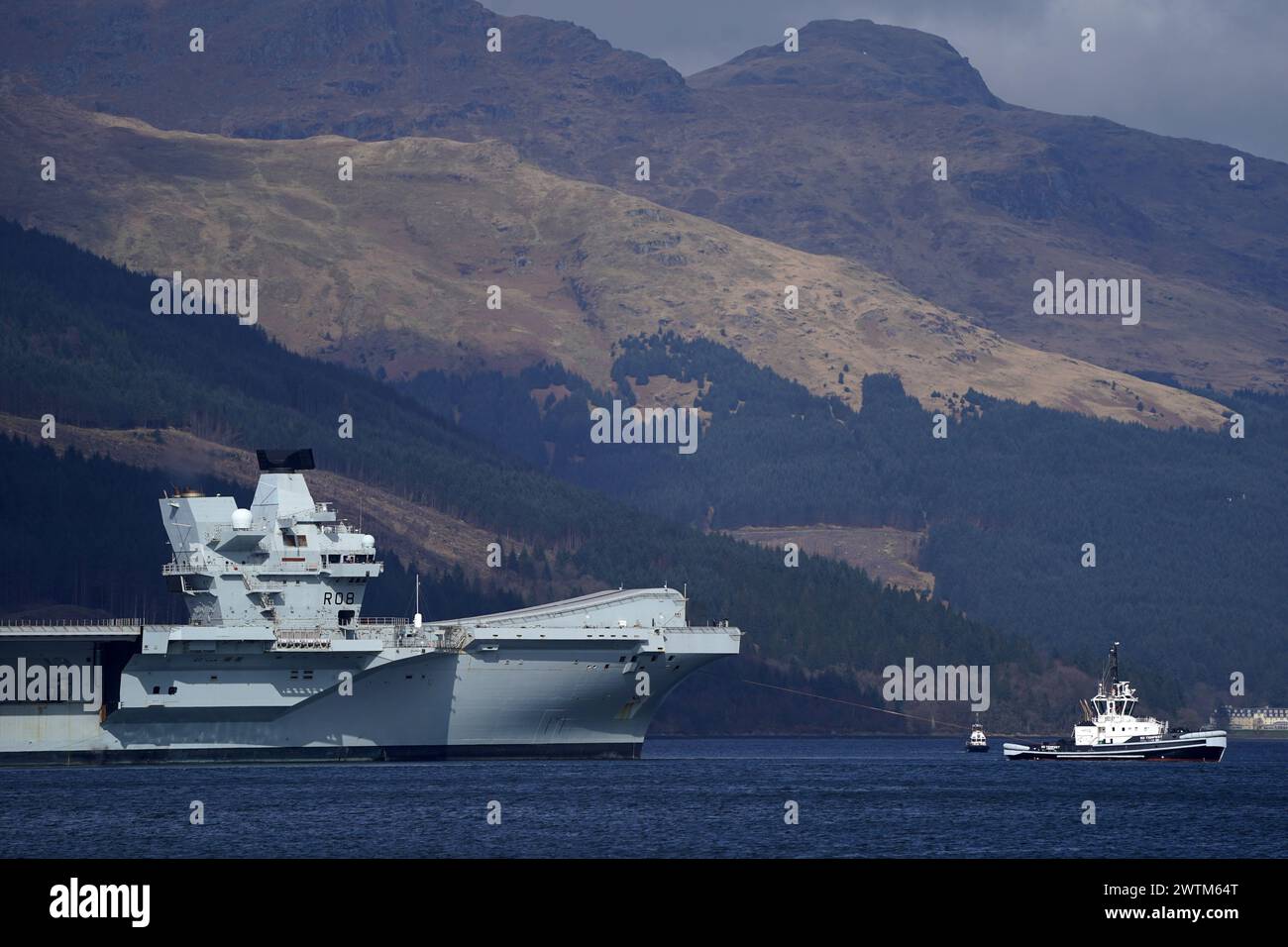 Le porte-avions de la Royal Navy HMS Queen Elizabeth quitte Glen Mallan dans le Loch long avec les Alpes Arrochar derrière. Date de la photo : lundi 18 mars 2024. Banque D'Images