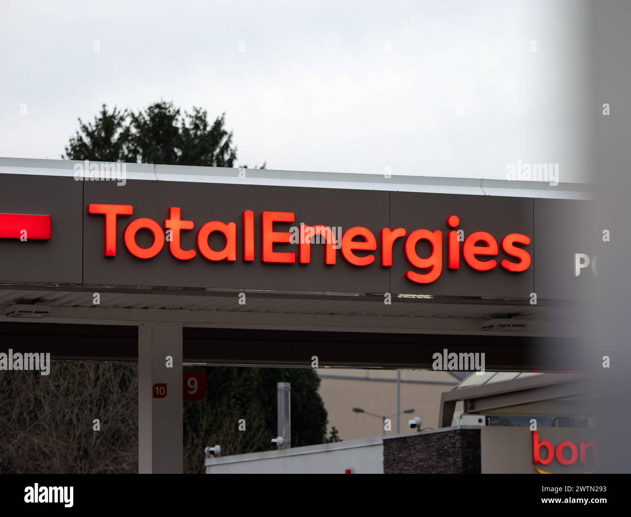 Logo TotalEnergies à l'extérieur d'un bâtiment de station-service. Publicité illuminée de la société française d'électricité et d'énergie. Banque D'Images