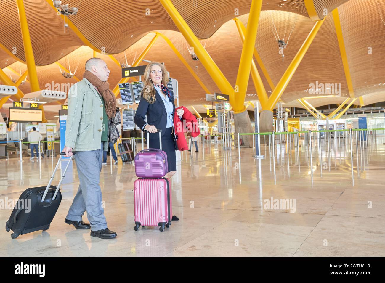 couple marchant dans l'aéroport avec une valise Banque D'Images