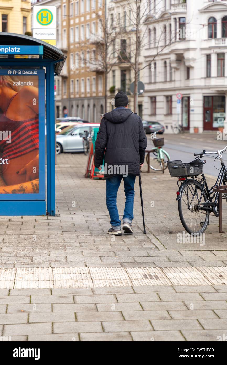 Munich, Allemagne - 25 décembre 2021 : homme âgé marchant avec une canne dans les rues de Munich, Bavière, Allemagne. Banque D'Images