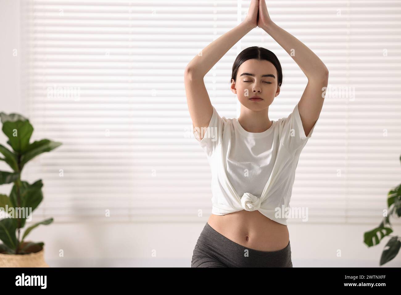 Fille pratiquant l'asana croissant dans le studio de yoga. Posture de fente haute Banque D'Images