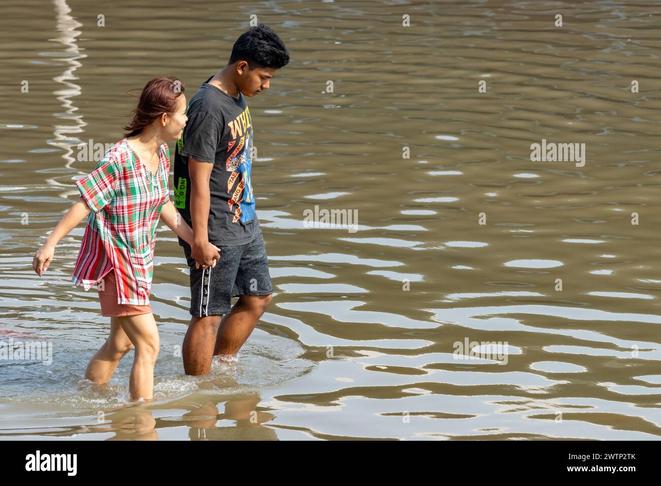 SAMUT PRAKAN, THAÏLANDE, février 02 2024, Un couple patente dans une rue inondée Banque D'Images