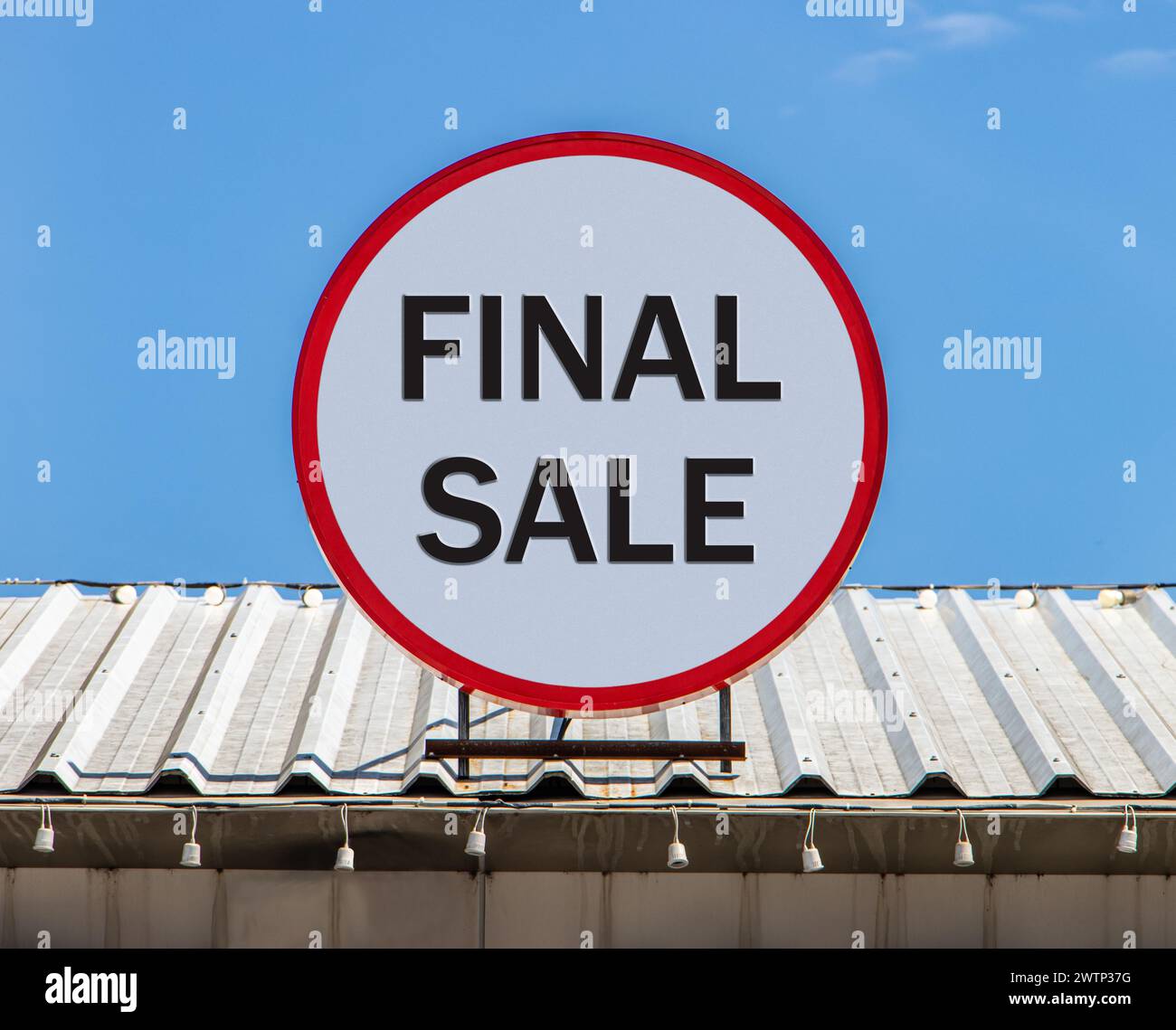 Un panneau d'affichage circulaire offrant une vente finale, est installé sur le toit. Banque D'Images