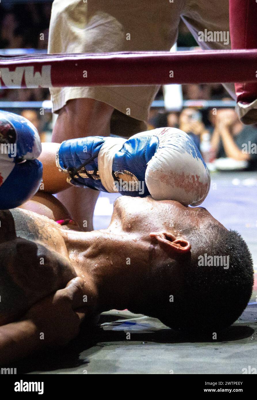 Le boxeur thaïlandais Petch si Nel est vu mettre son gant sur son visage après un Ko, lors des combats de Muay Thai, sur l'île de Koh Chang, en Thaïlande. Banque D'Images