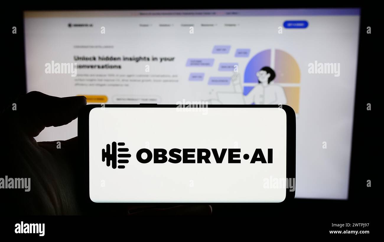 Personne tenant le téléphone portable avec le logo de la société américaine de centre de contact d'intelligence artificielle observer.ai devant la page Web. Concentrez-vous sur l'affichage du téléphone. Banque D'Images