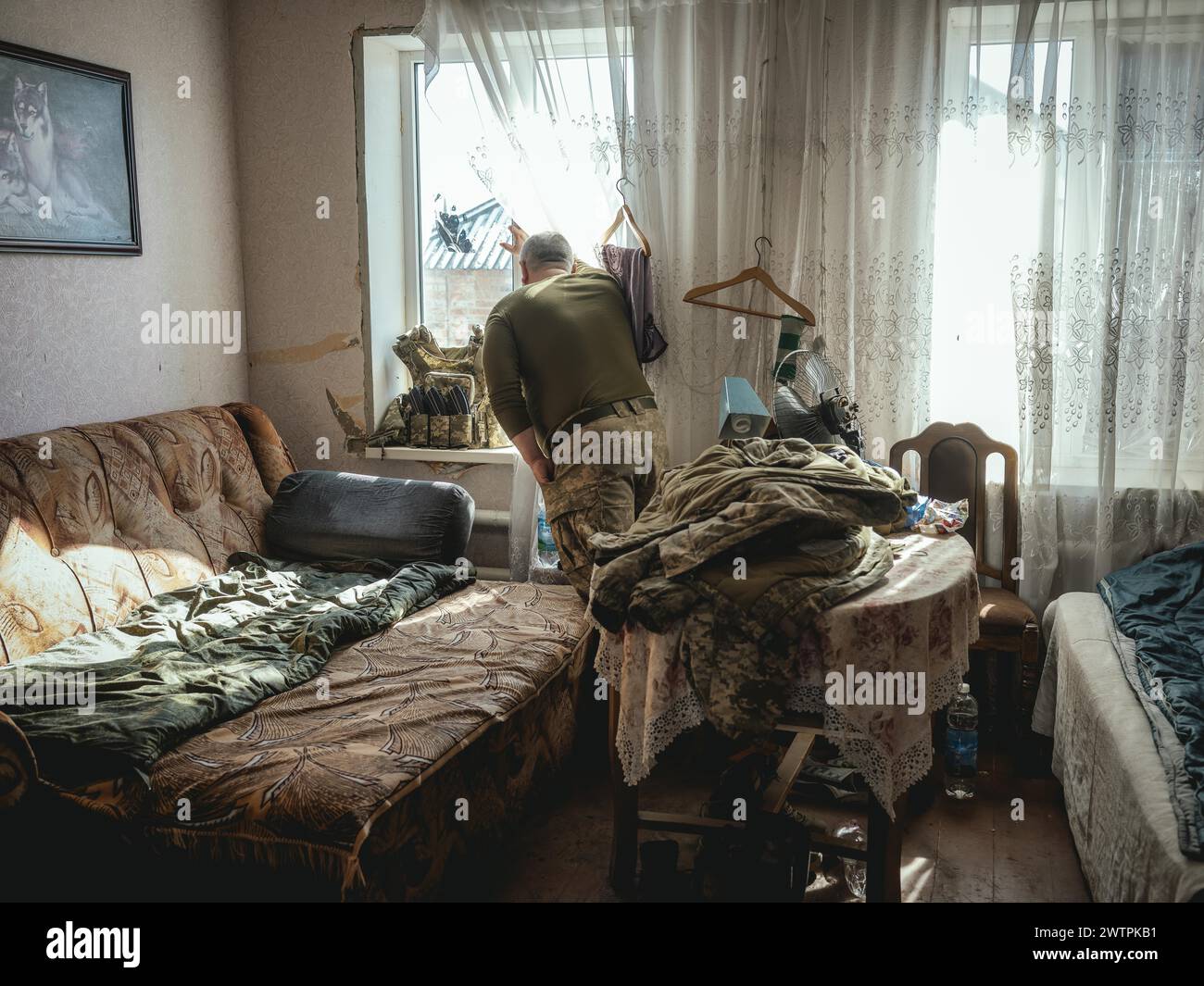 Gennady, 48 ans, stationné à Kupyansk, regardant par la fenêtre de la maison où son unité a pris position, Kupyansk est sous russe A. Banque D'Images